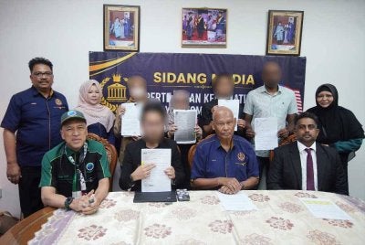 Musa (duduk, dua dari kanan) bersama Nadzim (kiri), Vikram (kanan) dan mangsa di Pejabat MCCC di ibu kota pada Isnin.