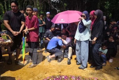 Saifulnizam tidak dapat menahan sebak selepas selesai pengebumian arwah anak dan isterinya di Tanah Perkuburan Islam Kampung Sanggang di sini pada Isnin. Foto SINAR HARIAN/NORAWAZNI YUSOF