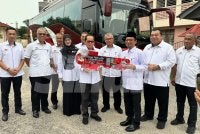 Mohd Azam (empat dari kiri) menyerahkan replika kunci bas kepada pihak sekolah. Foto: ADILA SHARINNI WAHID