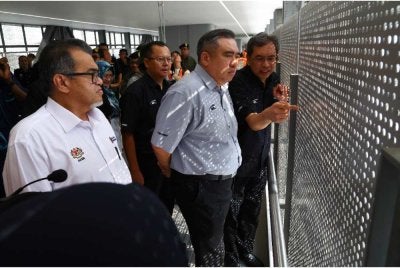 Anthony Loke (tengah) mendengar penerangan daripada Ketua Pegawai Eksekutif MRT Corp, Datuk Mohd Zarif Mohd Hashim (kanan) ketika melalui Jambatan Penyeberangan Orang (POB) pada lawatan tinajaun perkembangan RTS Link Johor Bahru-Singapura di Kompleks Bersepadu Imigresen, Kastam dan Kuarantin (ICQ), Bukit Cagar. Foto Bernama