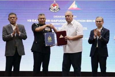 Saifuddin Nasution (kiri) bersama Menteri Komunikasi, Datuk Seri Fahmi Fadzil (kanan) menyaksikan pertukaran dokumen Perjanjian Persefahaman (MoU) antara Ketua Pengarah JIM, Datuk Zakaria Shaaban (tiga dari kiri) dan Pengerusi MCMC, Tan Sri Mohamad Salim Fateh Din (tiga dari kanan) di Kompleks Setia Perkasa. Foto Bernama 