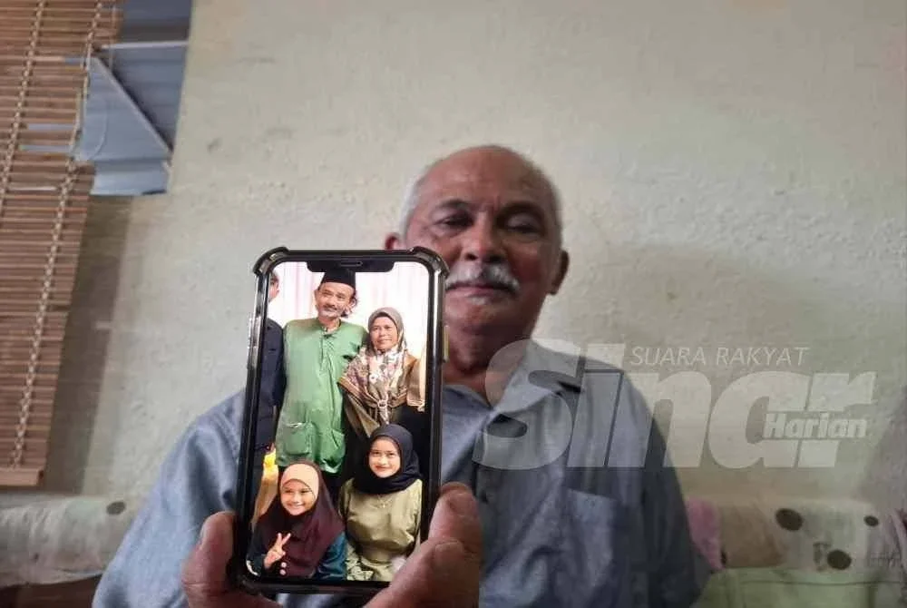 Mohd Nadzri menunjukkan gambar keluarga Allahyarham.