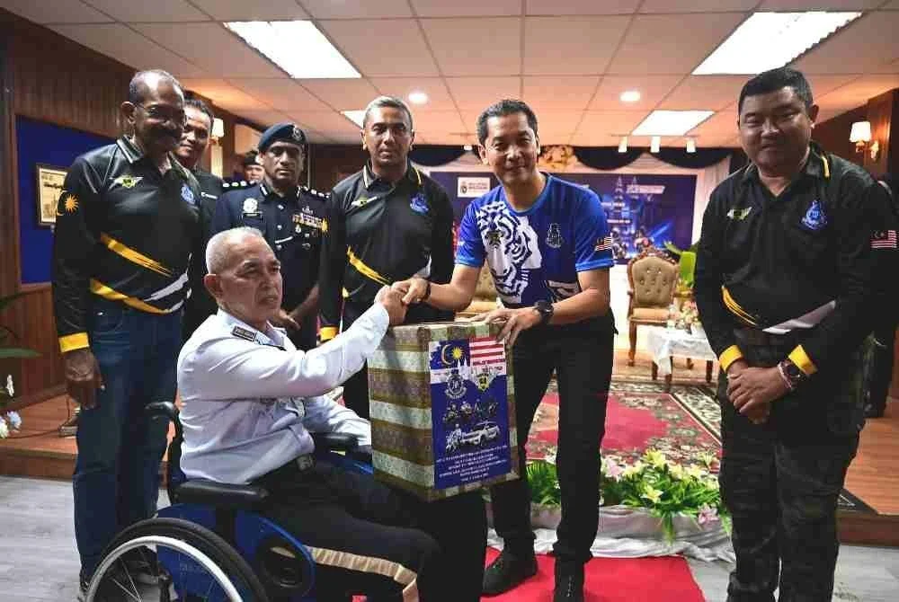 Mohd Khairi (tengah) menyampaikan sumbangan kepada pesakit kronik, rumah kebajikan serta Perkep kontinjen Terengganu sempena program amal konvoi 'charity ride' PDRM bersama Ipoh Superbike Club pada Rabu.