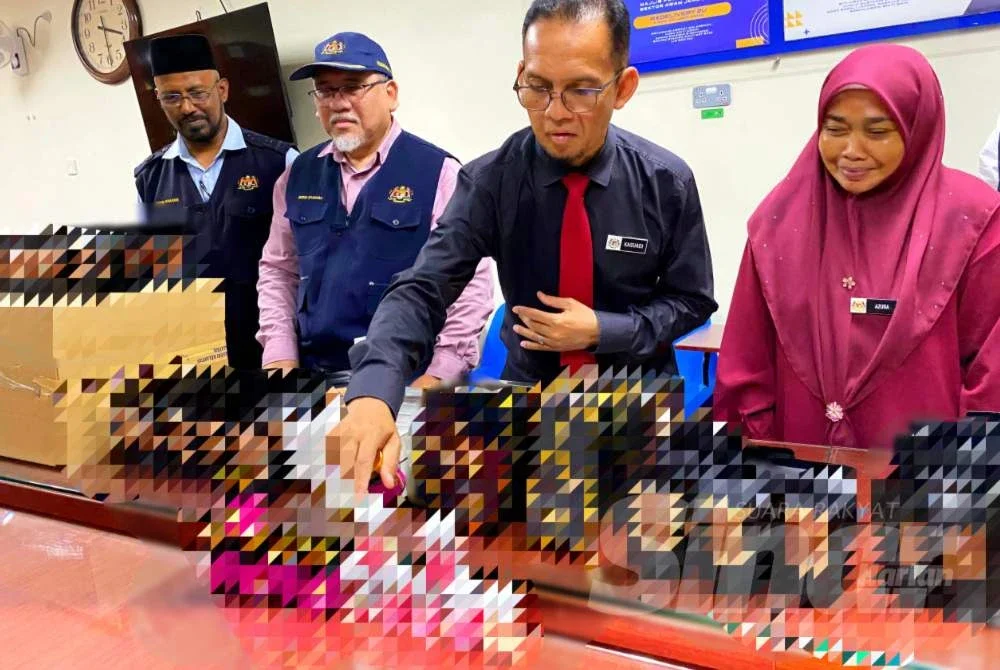 Dr Kasuadi (dua,kanan) menyusun produk kesihatan dimana sebahagian besarnya ubat kurus tidak berdaftar disyaki mengandungi racun berjadual yang dirampas oleh JKNK pada Rabu.Foto:SINAR HARIAN/HAZELEN LIANA KAMARUDIN