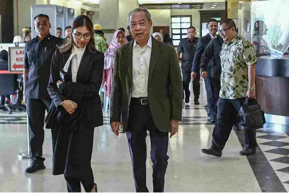 Muhyiddin (tengah) yang berdepan tujuh pertuduhan menyalahgunakan kedudukan serta pengubahan wang haram membabitkan projek Jana Wibawa hadir bagi perbicaraan kes itu di Mahkamah Tinggi, pada Rabu. Foto Bernama