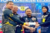 Mohd Yusoff (dua,kanan) menyaksikan penyampaian sumbangan kepada penerima pada Sambutan Hari Polis ke 219 dan Program Flag Off sempena Bulan Kebangsaan dan Kibar Jalur Gemilang Tahun 2026 di Ibu Pejabat Polis Kontinjen (IPK) Kelantan di Kota Bharu pada Rabu. Foto HAZELEN LIANA KAMARUDIN