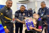 Mohd Yusoff (dua dari kiri) dan Alzafny (kiri) menyampaikan sumbangan pesakit kronik kepada kakitangan terpilih pada Sambutan Hari Polis ke 219 dan Program Flag Off sempena Bulan Kebangsaan dan Kibar Jalur Gemilang Tahun 2026 di IPK Kelantan di Kota Bharu pada Rabu. Foto: HAZELEN LIANA KAMARUDIN