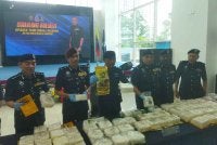 Fadil Marsus (empat dari kanan) menunjukkan dadah yang dirampas di sebuah kondominium di Brickfields pada 9 Ogos lalu.