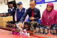 Dr Kasuadi (dua,kanan) menyusun produk kesihatan dimana sebahagian besarnya ubat kurus tidak berdaftar disyaki mengandungi racun berjadual yang dirampas oleh JKNK pada Rabu.Foto:SINAR HARIAN/HAZELEN LIANA KAMARUDIN