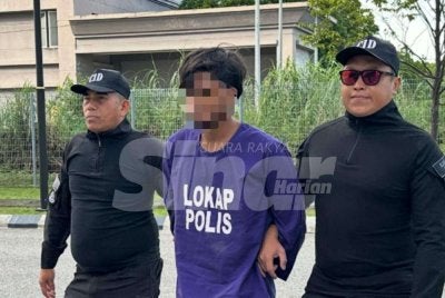 Tertuduh (tengah) ketika tiba dengan kenderaan polis di Mahkamah Kota Bharu pada Rabu. Foto: ADILA SHARINNI WAHID