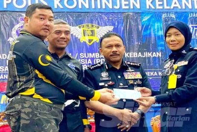 Mohd Yusoff (dua,kanan) menyaksikan penyampaian sumbangan kepada penerima pada Sambutan Hari Polis ke 219 dan Program Flag Off sempena Bulan Kebangsaan dan Kibar Jalur Gemilang Tahun 2026 di Ibu Pejabat Polis Kontinjen (IPK) Kelantan di Kota Bharu pada Rabu. Foto HAZELEN LIANA KAMARUDIN