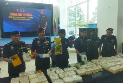 Fadil Marsus (empat dari kanan) menunjukkan dadah yang dirampas di sebuah kondominium di Brickfields pada 9 Ogos lalu.