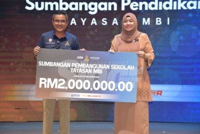 Ahmad Azri (kiri) menyerahkan replika cek kepada Wan Nor Ashikin pada Majlis Aspirasi Pendidikan Yayasan MBI 2026 pada Rabu.