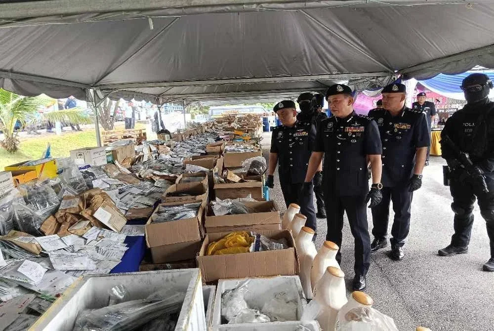Hoo Chuan Huat (depan ) menunjukkan dadah yang akan dilupuskan.