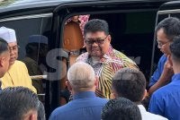 Ab Rauf (tengah) meninggalkan pekarangan Mahkamah Tinggi Melaka selepas hadir perbicaraan kes saman fitnah beliau pada Khamis. 
