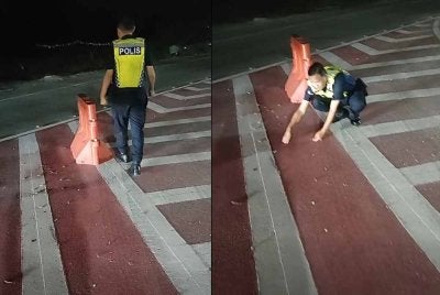 Tangkap layar video tular yang memaparkan seorang anggota polis mengutip paku yang ditabur pihak tidak bertanggungjawab di jejambat Cybersouth. 