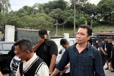 Tertuduh (kanan) dihadapkan ke Mahkamah Sesyen dan Mahkamah Majistret Johor Bahru pada Khamis.