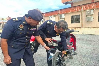 Mohammad Yusoff (kanan) menunjukkan antara kesalahan pengubahsuaian melampau yang dilakukan penunggang motosikal.