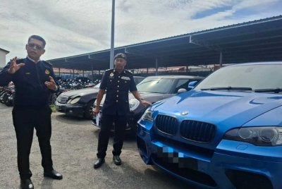 Mohammad Yusoff (kiri) menunjukkan antara kereta mewah yang masih dalam tindakan sita atas kegagalan memiliki perlindungan insurans dan cukai jalan hasil Op Luxury dilaksanakan JPJ Perak.