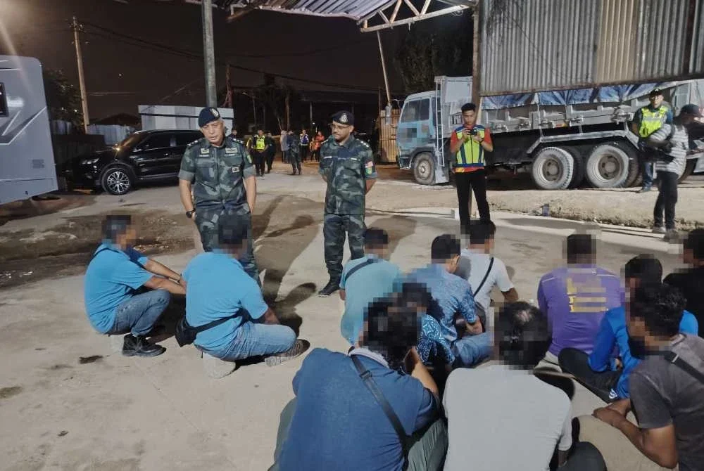 Antara individu yang ditahan dalam serbuan kegiatan cuci pasir haram di Jalan Lapangan Terbang Subang Lama, Shah Alam pada Khamis.