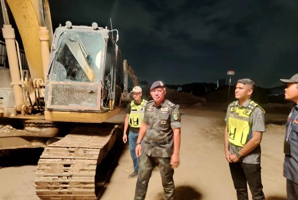 Hakemal (dua dari kiri) meninjau lokasi serbuan membabitkan kegiatan perlombongan pasir haram di Jalan Lapangan Terbang Subang Lama, Shah Alam pada Khamis.