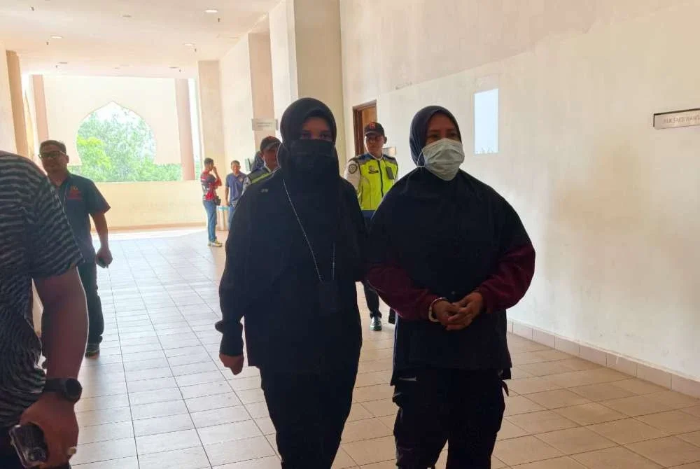 Tertuduh (kanan) diiringi pegawai JPN Pahang ketika dibawa keluar dari mahkamah selepas selesai sebutan kes dan dijatuhkan hukuman.