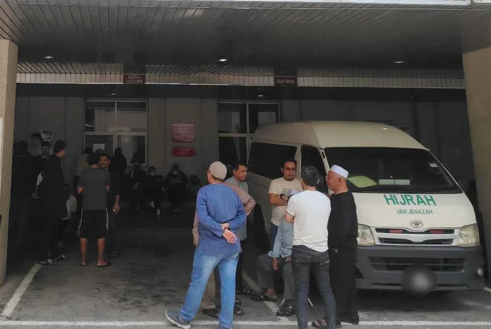 Waris dan rakan mangsa menunggu di pekarangan Jabatan Forensik Hospital Putrajaya pada Jumaat.