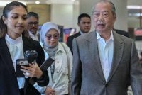 Muhyiddin (kanan) hadir di Mahkamah Tinggi pada Jumaat bagi perbicaraan tujuh pertuduhan menyalahgunakan kedudukan dan pengubahan wang haram. Foto: Bernama 