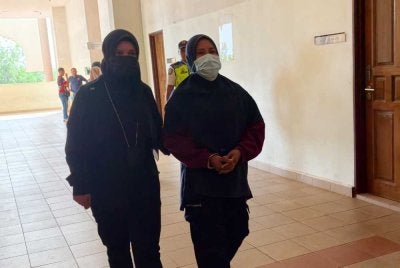 Tertuduh (kanan) diiringi pegawai JPN Pahang ketika dibawa keluar dari mahkamah selepas selesai sebutan kes dan dijatuhkan hukuman.