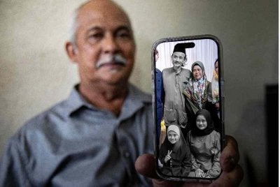 Ahli keluarga mangsa yang terkorban dalam kemalangan lori Jabatan Imigresen Malaysia (JIM) di Jalan Sultan Ismail awal pagi tadi, Mohd Nadzri Razali, 69, menunjukkan gambar keluarga adik perempuannya.