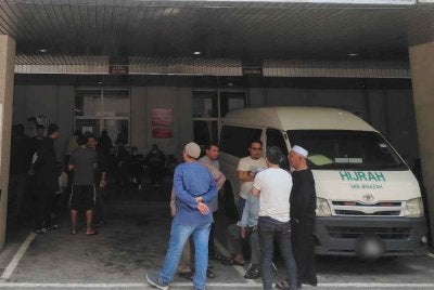 Waris dan rakan mangsa menunggu di pekarangan Jabatan Forensik Hospital Putrajaya pada Jumaat.