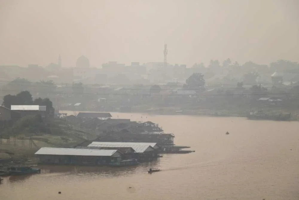 Jerebu menyelubungi kawasan perumahan di tepi Sungai Kahayan di Palangkaraya, Kalimantan Tengah susulan kebakaran hutan dan tanah yang berlaku secara meluas di pelbagai lokasi di seluruh pulau tersebut. Foto AFP