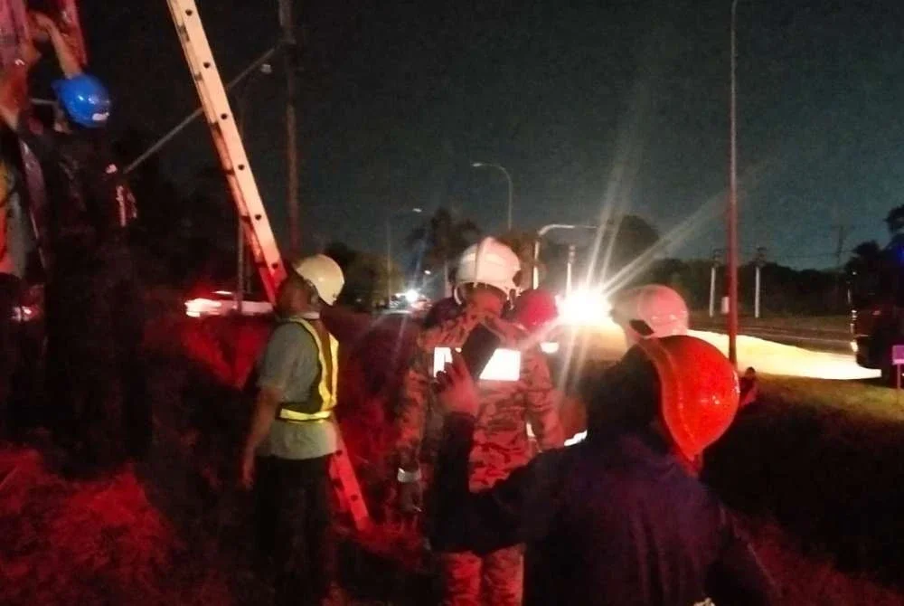 Pasukan bomba menjalankan operasi menurunkan mangsa yang terkena renjatan di tiang elektrik dalam kejadian di Bandar Tabin Jaya, Sandakan.