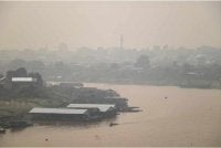 Jerebu menyelubungi kawasan perumahan di tebing Sungai Kahayan di Palangkaraya, Kalimantan Tengah pada Jumaat. - Foto AFP