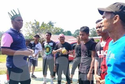 Saravanan (kiri) bersama masyarakat di Kampung Orange Asli Batu 9 di sini pada Sabtu.