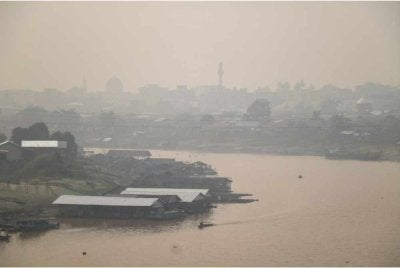 Jerebu menyelubungi kawasan perumahan di tebing Sungai Kahayan di Palangkaraya, Kalimantan Tengah pada Jumaat. - Foto AFP