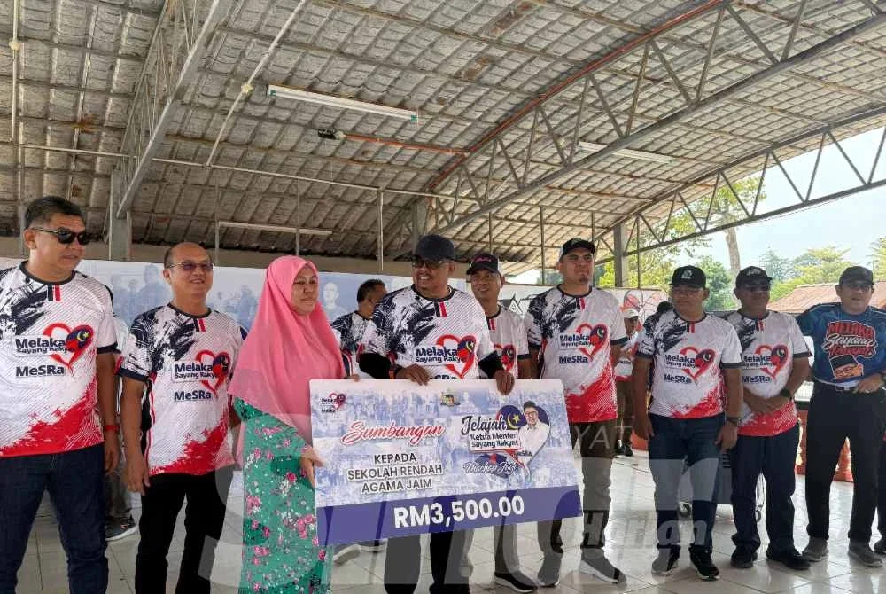 Ab Rauf (empat dari kiri) menyampaikan sumbangan kepada penerima sempena Jelajah Ketua Menteri Sayang Rakyat @ DUN Machap Jaya di Felda Menggong pada Ahad.