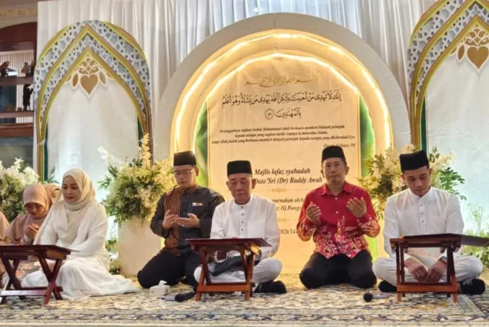 Ruddy (depan, tengah) bersama isteri (depan, kiri) dan anak (kanan) ketika majlis melafaz dua kalimah syahadah di kediaman mereka di Kampung Salimpodon Laut, Pitas, Kudat.
