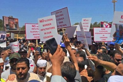 Penunjuk perasaan berkumpul di hadapan pejabat UNHCR di Tripoli bagi mendesak penutupan pejabat tersebut. - Agensi