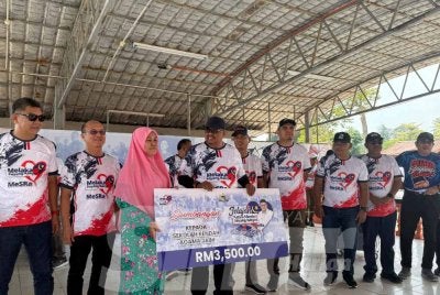 Ab Rauf (empat dari kiri) menyampaikan sumbangan kepada penerima sempena Jelajah Ketua Menteri Sayang Rakyat @ DUN Machap Jaya di Felda Menggong pada Ahad.