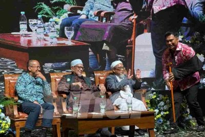 Muhamad Muqharabbin (kanan) menerima tongkat Abdul Hadi yang dibida dengan harga RM16,500.