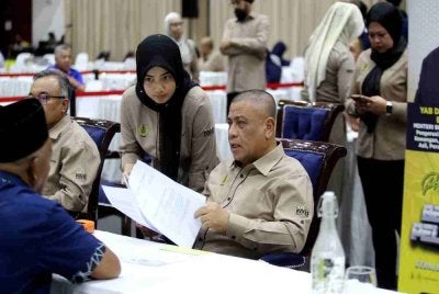 Saarani (kanan) menyatuni orang ramai yang hadir ke Program Mesra Hari Bertemu Pelanggan di Dewan Jubli Perak, Kuala Kangsar pada Isnin.
