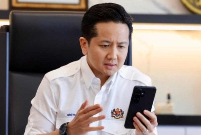 Arthur ketika membuat panggilan telefon bersama rakan sejawatnya dari Indonesia, Jumhur Hidayat.