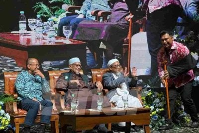Muhamad Muqharabbin (kanan) membida tongkat milik Presiden Pas (dua dari kiri) pada nilai RM16,500 dalam Majlis Makan Malam Amal Pas Negeri Melaka pada Ahad. 