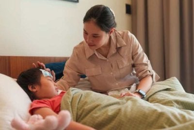 Seorang ibu meletakkan pelekat penyejuk pada dahi anaknya yang mengalami demam. Gambar hiasan iStock