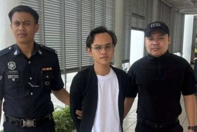 Mohd Izham (tengah) dibawa ke Mahkamah Majistret Selayang pada Isnin.
