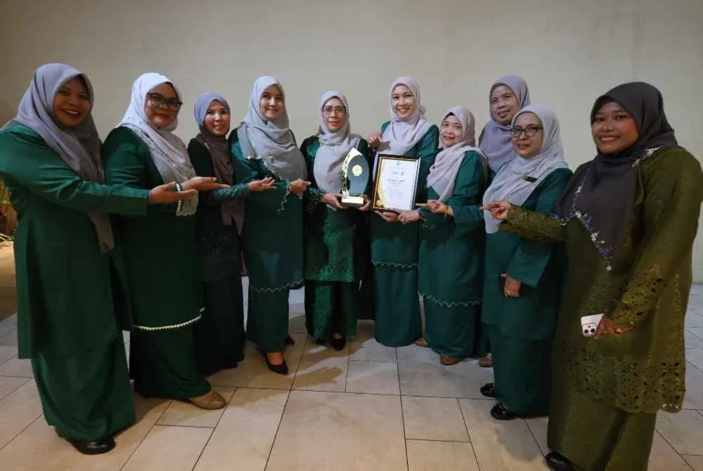 Norzita (lima dari kiri) menunjukkan anugerah diterima NGO tersebut bersama ahli jawatankuasa Pertubuhan Wanita Prihatin Perak sempena Sambutan Maulidur Rasul Peringkat Negeri Perak Tahun 1448H/2026M di Pusat Konvensyen Casuarina di sini pada Selasa.