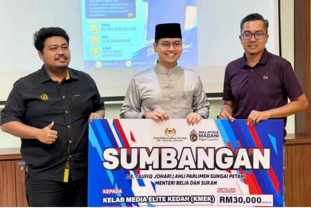 Mohammed Taufiq menyampaikan sumbangan replika cek RM30,000 kepada Presiden KMEK, M Hifzuddin Ikhsan (kanan).