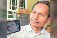 Mazlan menunjukkan gambar Allahyarham Nor Maisarah. 
