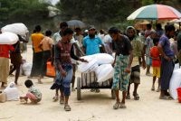 Pelarian Rohingya membawa guni beras yang diterima sebagai bantuan catuan daripada Program Makanan Sedunia Pertubuhan Bangsa-Bangsa Bersatu (WFP) pada 18 April lalu. Foto Reuters